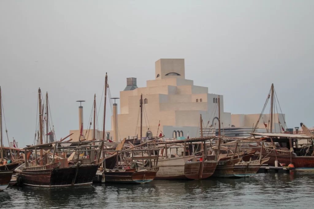 Traditional dhow boats at Doha waterfront with Museum of Islamic Art – Places to Visit in Doha