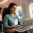 Flight Booking Tips: Happy Indian traveler booking cheap flight tickets on a laptop from Bengaluru to Singapore for 2026 trip.