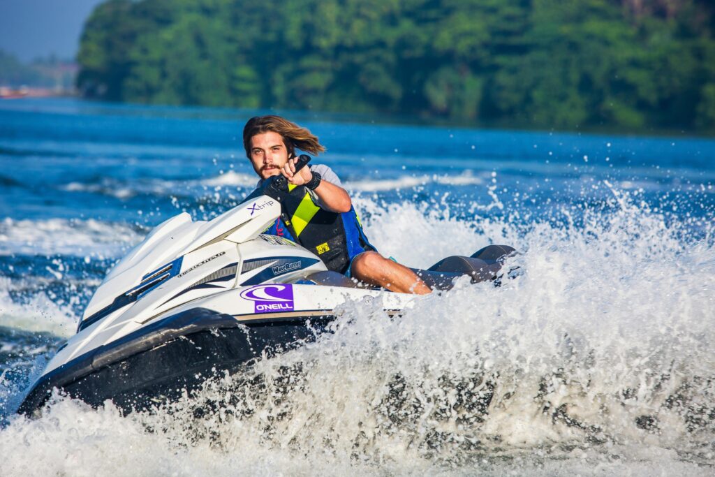Rider on a jet ski speeding across the calm waters of Water Sports heaven Negombo Lagoon, Sri Lanka