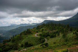 anoramic view of Sri Lanka’s Knuckles Mountain Range with lush green valleys, rugged peaks, and mist rising over the landscape