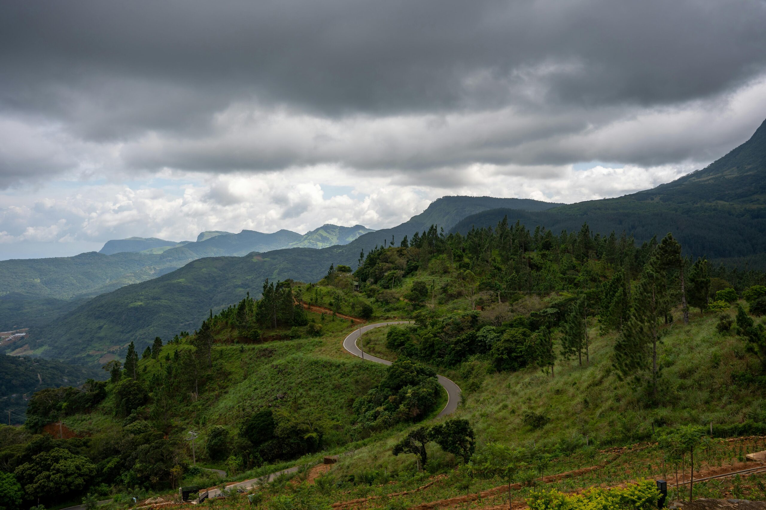 anoramic view of Sri Lanka’s Knuckles Mountain Range with lush green valleys, rugged peaks, and mist rising over the landscape