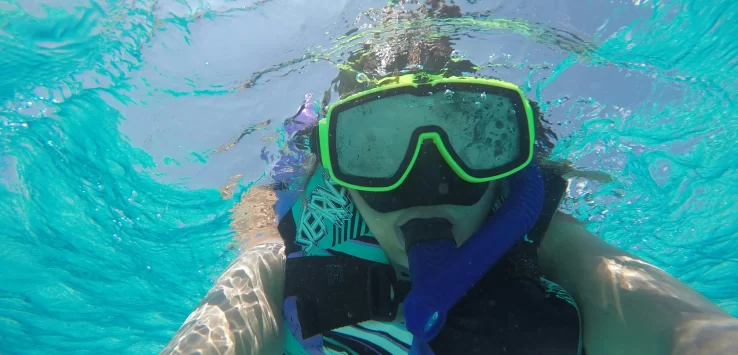 Scuba diver exploring coral reef with sea turtle in Hikkaduwa, Sri Lanka