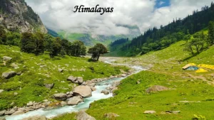 A pristine glacial river flowing through a vibrant green Himalayan valley with camping tents, a paradise for Indian travel.