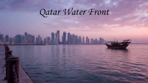 A wide view of the clean, paved Doha Corniche pedestrian walkway alongside palm trees and blue waters, a favorite outdoor option among places to visit in Doha