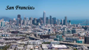 An aerial panoramic view of the San Francisco skyline showcasing downtown skyscrapers and the bay, highlighting iconic cities to visit in America.