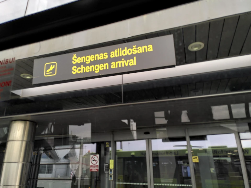 Schengen visa guide Traveler arriving at a Schengen airport immigration checkpoint in Europe with a valid Schengen Visa
