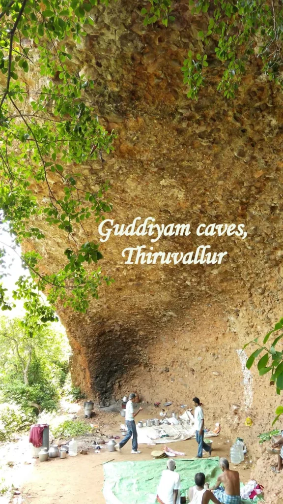 Gudiyam Caves in Tiruvallur showing a large natural rock shelter surrounded by trees