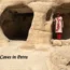 Woman standing inside one of the ancient rock-cut sandstone caves in Petra, Jordan.