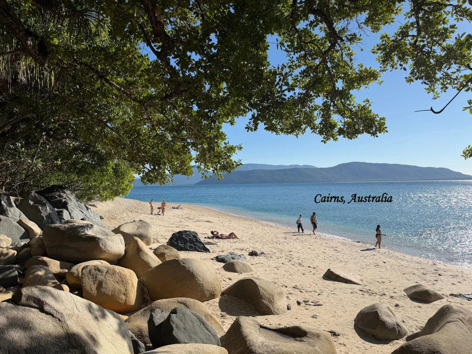 Cairns Australia beach with clear blue water, sandy shore and tropical coastline