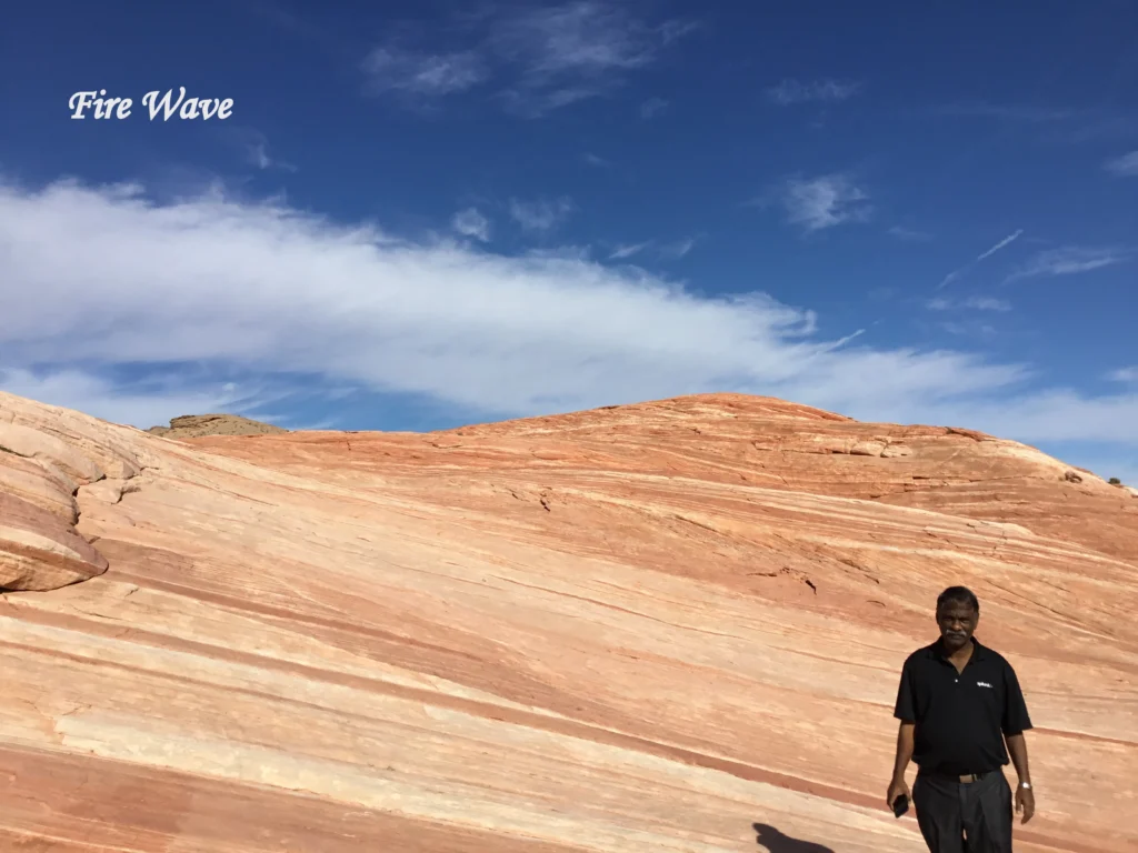 Fire Wave at Valley of Fire State Park, Nevada, showing smooth red and cream sandstone formations beneath a bright blue sky.