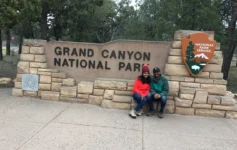 Iconic Grand Canyon National Park entrance sign, surrounded by trees at this famous Arizona natural landmark.